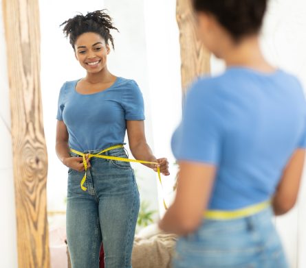 Happy Black Girl After Weight Loss Measuring Waist At Home
